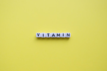 Vitamin word on a yellow background. 