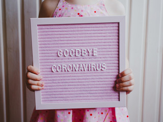 Goodbye Coronavirus. Girl holding inscription Goodbye Coronavirus