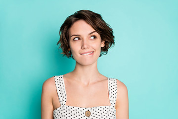 Closeup photo of pretty wondered lady look empty space see interesting advert banner bite lips wear casual white dotted overall isolated pastel teal color background