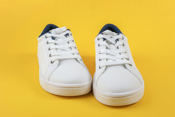 White sports shoes, sneakers with shoelaces on a yellow background. Sport lifestyle concept Top view Flat lay Copy space