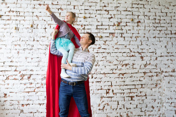 Obraz na płótnie Canvas happy father in superhero costume and his daughter