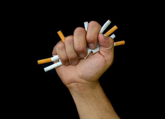 close up man's hand is crumpling a cigarette in his hand, the concept of quitting smoking to...