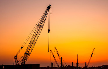 Fototapeta premium Construction site crain colorful sunset background