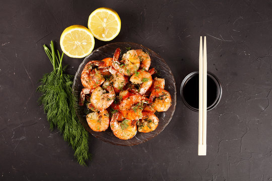 fried king prawns in a plate, lemon, dill, top view