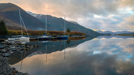 still and calm reflections on Loch Leven anchorage after sunset 