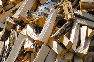 A pile of wood for kindling. Big pile of firewood. Deforestation, forest clearing, in the backyard and forest. 