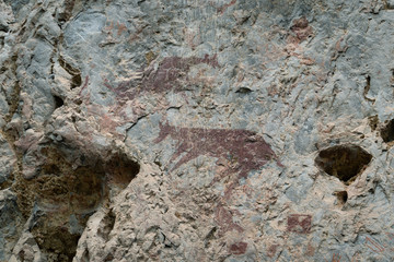 Ancient paintings painted by prehistoric people on the cliffs showing various stories of that era.