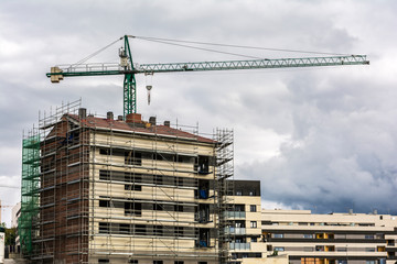 Naklejka premium Crane in the construction works of a residential building