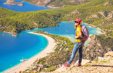 Sporty hiking girl over Oludeniz lagoon in sea landscape view of beach, Turkey. Travel and healthy...