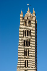 Fototapeta na wymiar Closeup of the ancient bell tower of the Siena Cathedral (Duomo di Siena, Santa Maria Assunta,1220-1370). Tuscany, Italy, Europe