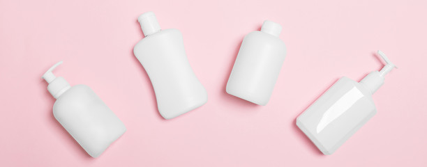 Set of White Cosmetic containers isolated on pink background, top view with copy space. Group of plastic bodycare bottle containers with empty space for you design