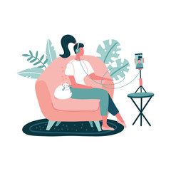 Young Woman in headset recording podcasts, online training, music using smartphone on a tripod. Girl sitting in armchair with cat at home on white background. Vector flat hand drawn illustration.