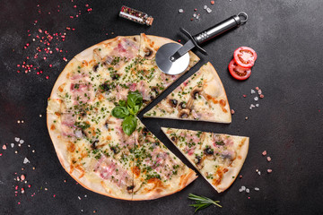 Fresh hot pizza with bacon, onions, greens and tomatoes made in an oven