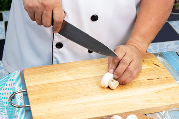 Chef cut mushrooms with a knife