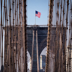 Obraz premium New York City, USA - October 18, 2016: American flag on top of Brooklyn Bridge