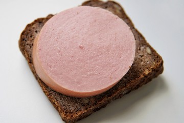 A typical Russian sandwich made from black rye bread with sunflower seeds and traditional Russian sausage. Simple food for poor people.