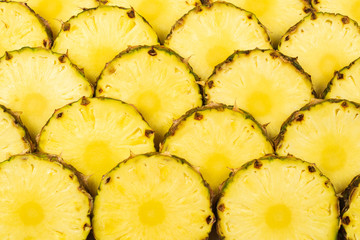 Pineapple juicy yellow slices background. Top view.