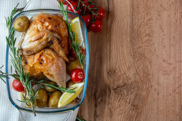 baked chicken with mushrooms and potatoes close-up in a baking dish on a table. horizontal top view from above