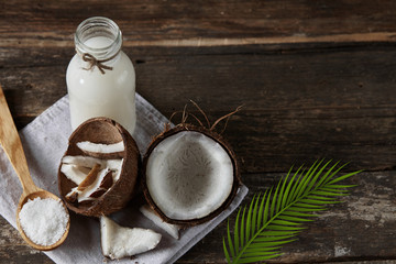 Ripe half cut coconut on a wooden background. Ripe half cut coconut on a wooden background. Coconut cream and oil.