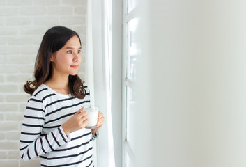 asian beauty woman friends standing and holding cup of milk close window and curtain in morning with copy space.