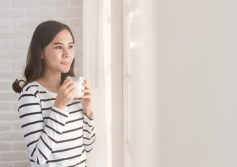 asian beauty woman friends standing and holding cup of milk close window and curtain in morning with copy space.