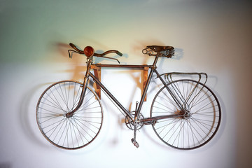 Fototapeta na wymiar Rusty old bicycle hanging on a white wall
