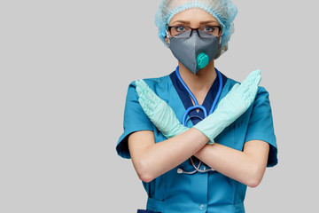 female doctor with stethoscope wearing protective mask and latex gloves over light grey background