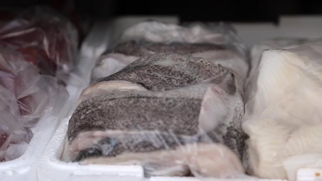 Pan over different fish and seafood at in a fish vendors car.