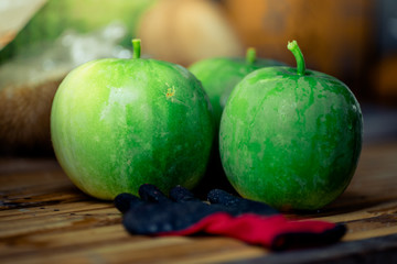 Blurred abstract background of green fruit placed on a wooden table waiting to be sold on the market.