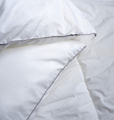 White soft pillows. Soft white bed linen. Background. Texture. Minimalism.