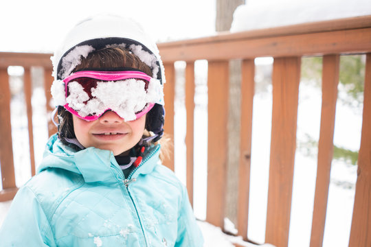 Portrait of young girl with snow covered ski goggles