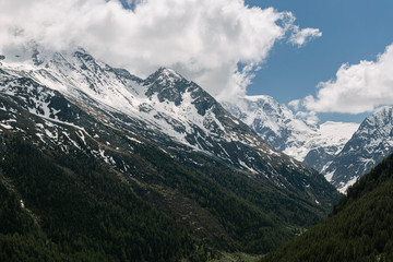 Peak of the mountains in the clouds on a background of blue sky.