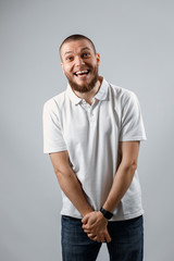 Portrait of a handsome young shy man in a white T-shirt on a gray background. isolated, Copyspace