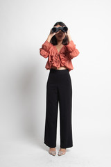 Full body of young Asian woman with binoculars .