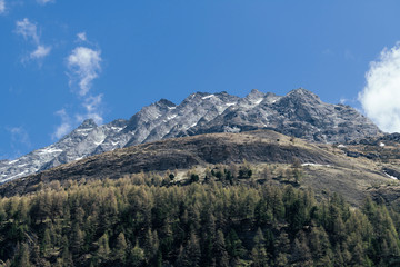 Obraz premium Peak of the mountains in the clouds on a background of blue sky.