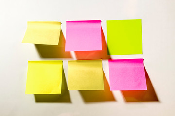 Multi-colored square post-it notes pasted on a white wall
