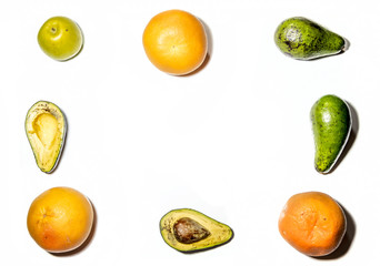 avocado, Apple and oranges are laid out on a white background