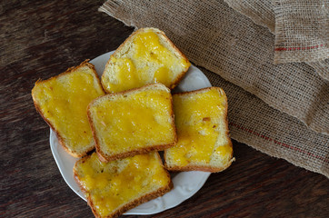 Bread with honey on a dark wooden background.