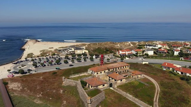 DRONE AERIAL FOOTAGE - The Farol de Esposende (Esposende Lighthouse) set in front of the Fort of Sao Joao Baptista de Esposende. The two sides of Restinga de Ofir, Portugal.