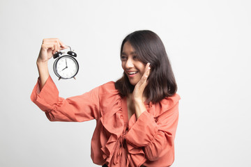 Young Asian woman is stressed with a clock .