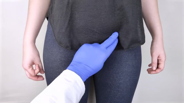 A woman suffers from pain in the pelvic organs. The gynecologist examines the patient. Painful location, female disease, cystitis, or urinary incontinence