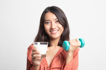 Fototapeta premium Healthy Asian woman drinking a glass of milk and dumbbell .