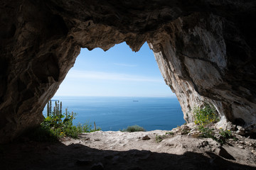 View looking out from one of the Goats Hair Twin Caves in Gibraltar - obrazy, fototapety, plakaty