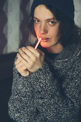 Fototapeta premium Young Female setting fire to cigarette with lighter