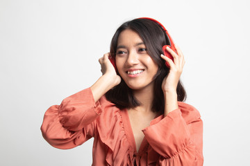 Pretty asian girl listening music with her headphones .