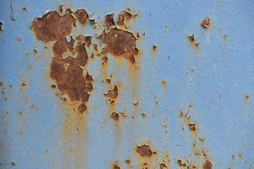 Photo of an old rusty wall with blue peeling paint for textures