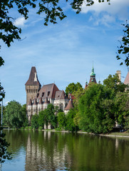 Old castle in the park between green trees located in Budapest, Hungary. Historic famous landmark in town. Cityscape of tourism destination in European city. Tourism concept. 