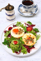 Fried eggs with pumpkin seeds and cherry tomatoes on a white plate. The concept of Breakfast. Copy of the space.Top view.