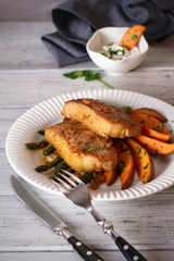 Juicy broiled pork chop steaks with asparagus, sweet potatoes and yogurt sauce. vertical image