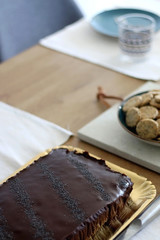 Various food served on a table: Chocolate poppy seed cake, strawberries, whipped cream and crackers. Selective focus.